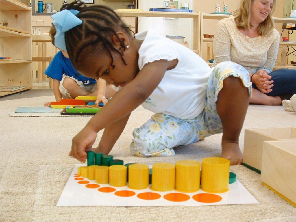 niña jugando con juguetes de madera desestructurados montessori